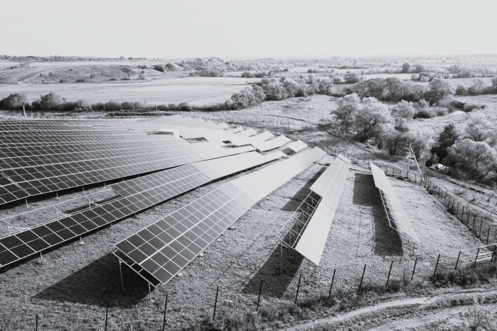 Aerial view of solar power plant under construction on green field. Assembling of electric panels for producing clean ecologic energy.