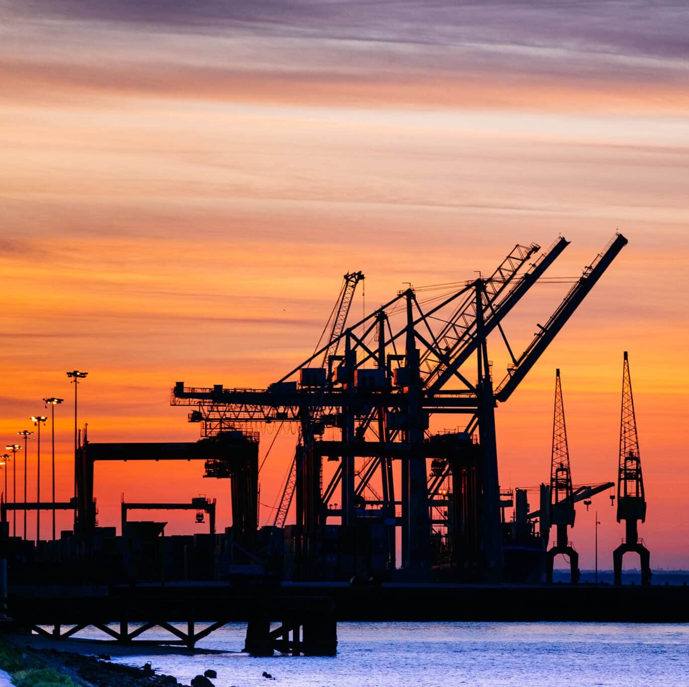 A beautiful silhouette of port machinery during sunset