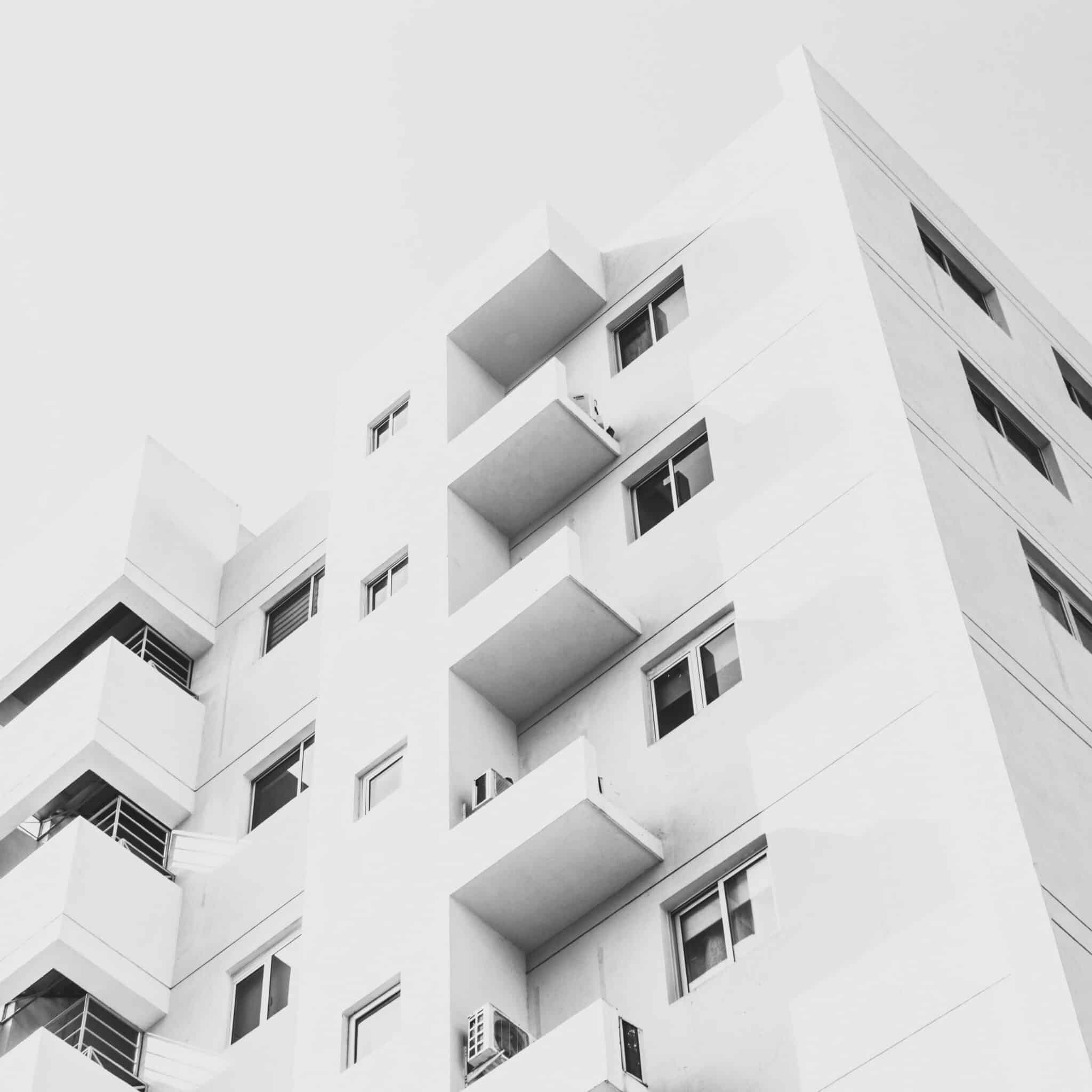 A low angle shot of a facade of a white modern building under a blue clear sky