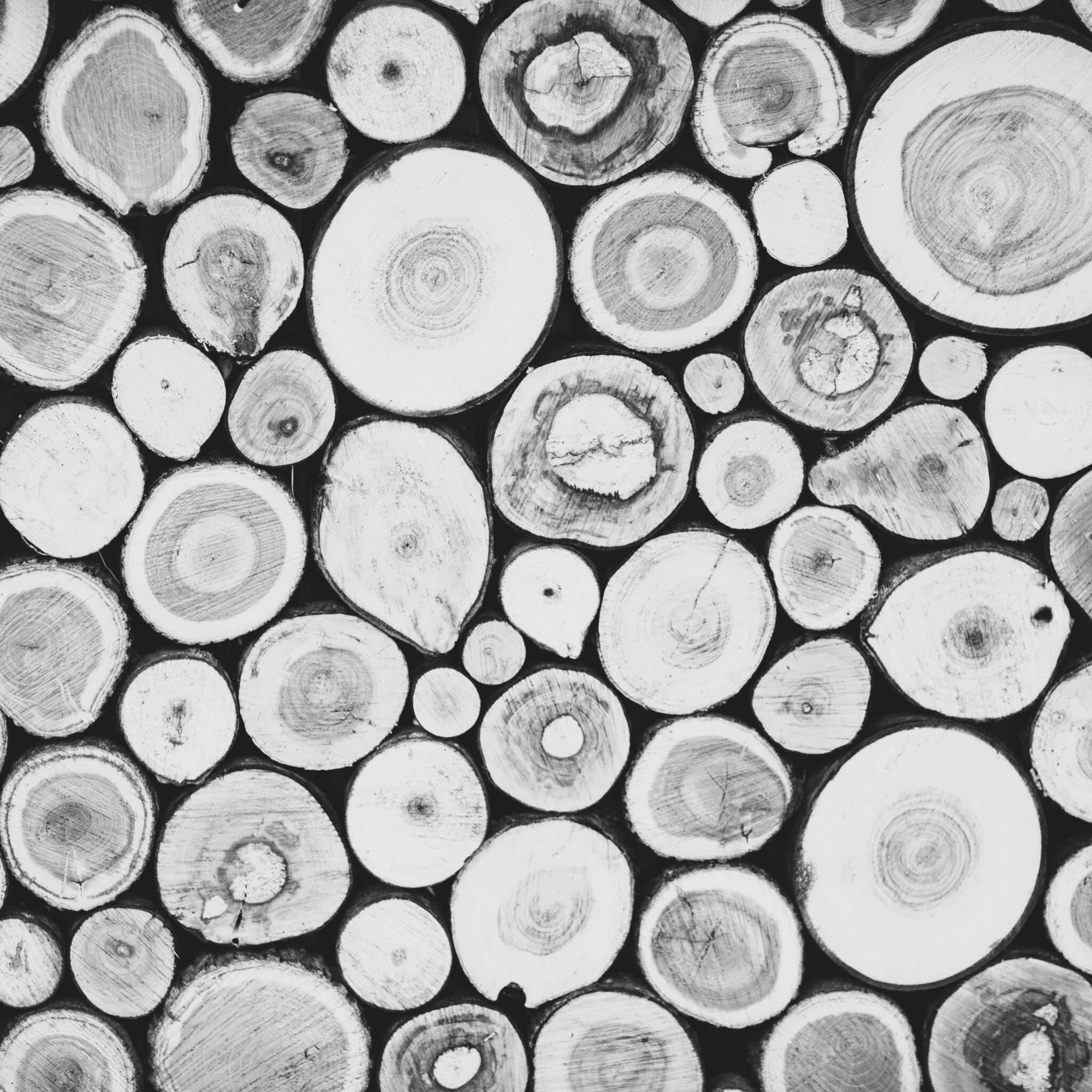 Christmas texture background of dry wooden log cabins. Woodpile of cut Lumber for forestry industry.